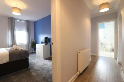 a room with a bedroom with a bed and a television at Lovely 2 BR flat, sleeps 4 in Chapelhall