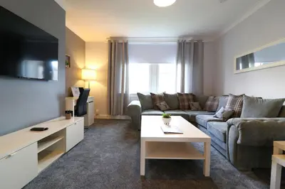 a living room with a couch and a table at Lovely 2 BR flat, sleeps 4 in Chapelhall