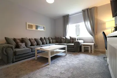 a living room with a couch and a table at Perfect 4 BR flat, sleeps 8 in Chapelhall