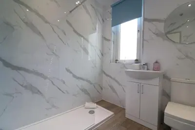 a bathroom with a white tub and a sink at Perfect 4 BR flat, sleeps 8 in Chapelhall