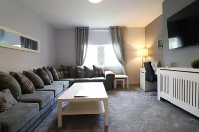 a living room with a couch and a table at Perfect 4 BR flat, sleeps 8 in Chapelhall