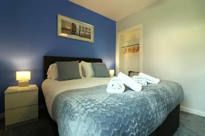 a bedroom with a bed with two towels on it at Perfect 4 BR flat, sleeps 8 in Chapelhall