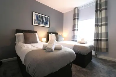a bedroom with two beds and a window at Perfect 4 BR flat, sleeps 8 in Chapelhall
