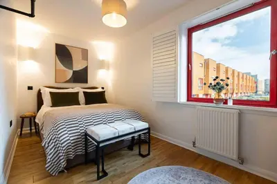 a bedroom with a bed and a large window at Botanic House - 3BR Home - Private Parking in Glasgow