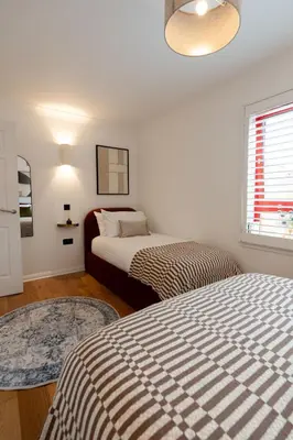 a bedroom with two beds and a window at Botanic House - 3BR Home - Private Parking in Glasgow