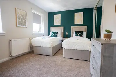 two beds in a room with green walls at 2 BDR House At Caledonia Luxe Stays Short Lets & Serviced Accommodation Hamilton in Hamilton