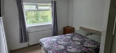 a bedroom with a bed and a window at 3 bedrooms home away from home in Uphall