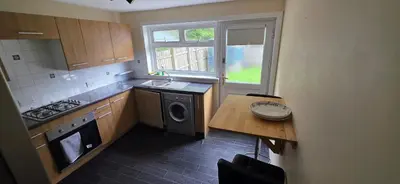 a kitchen with a table and a sink and a dishwasher at 3 bedrooms home away from home in Uphall