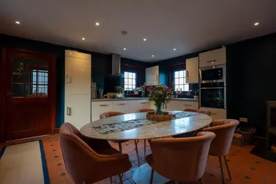 a kitchen with a wooden table and chairs and a table and a kitchen at The Cottage at Barraston Farm in Glasgow