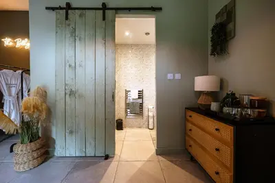 a hallway with a wooden door in a room at Barraston Farm in Glasgow
