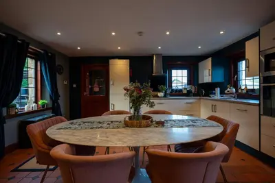 a kitchen with a dining room table and chairs at Barraston Farm in Glasgow