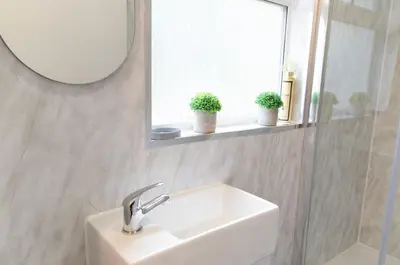 a white sink in a bathroom with a mirror at Beech Cottage in Armadale
