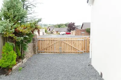 a wooden fence with a wooden gate in a driveway at Beech Cottage in Armadale