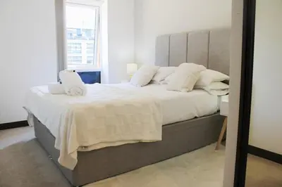 a bedroom with a large bed with white sheets and pillows at The Sunrise Den, Modern 2-Bed Apartment, Free Parking in Yarrow