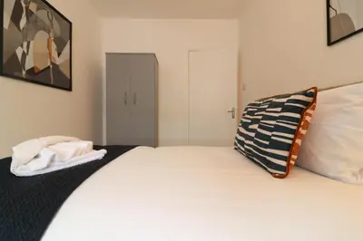 a bedroom with a large white bed with a pillow at Signature - Oak House in Coatbridge