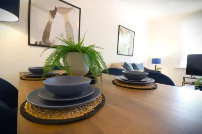 a table with three bowls and a plant on it at Signature - Oak House in Coatbridge