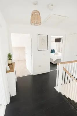 a white room with a black floor and a bedroom at 3BR Detached Home, Driveway & Large Rear Garden in Hogganfield