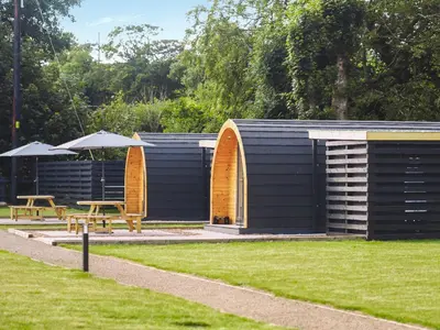 a building with two tables and umbrellas in a park at Arran - Uk48415 in Dalry