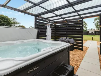 a hot tub in a backyard with a pergola at Arran - Uk48415 in Dalry