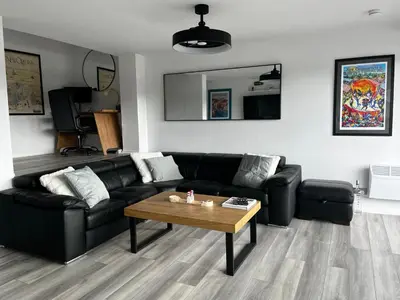 a living room with a black couch and a table at City Centre Apartment in Glasgow