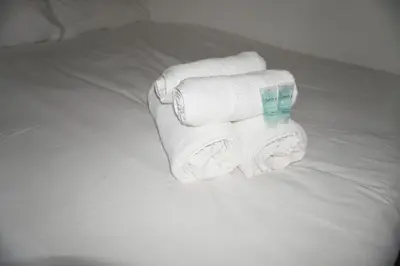 a pile of towels sitting on a bed at Glasgow Riverview Apartment in Glasgow