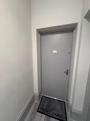 a white door with a welcome mat in front of it at Taobh na Mara - Macaulay Letting in Helensburgh