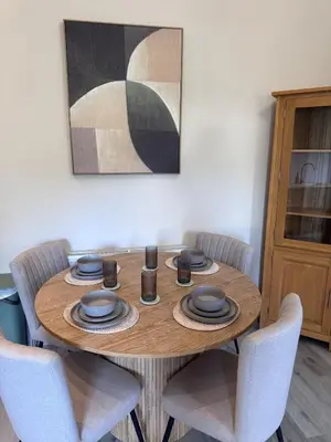 a dining room table with chairs and a painting at The Comet - Macaulay Letting in Helensburgh