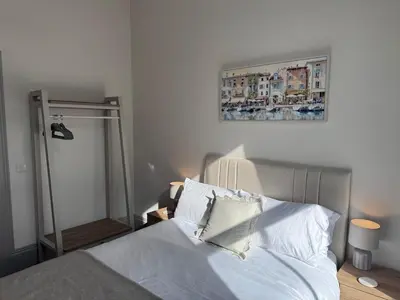 a bed with white sheets and pillows in a bedroom at The Comet - Macaulay Letting in Helensburgh