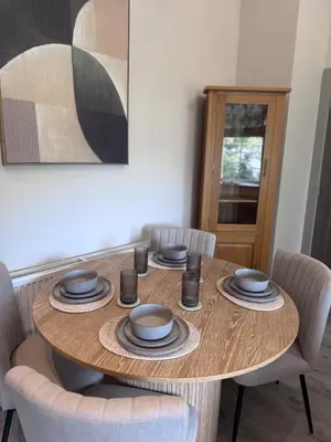 a wooden table with chairs and plates on it at The Comet - Macaulay Letting in Helensburgh