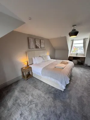 a bedroom with a large bed and a window at Abhaille Chluaidh - Macaulay Letting in Helensburgh