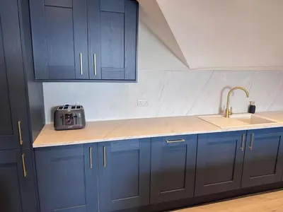 a kitchen with blue cabinets and a sink at Abhaille Chluaidh - Macaulay Letting in Helensburgh