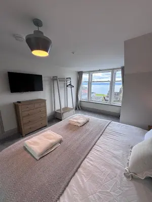 a bedroom with a large bed and a television at Abhaille Chluaidh - Macaulay Letting in Helensburgh