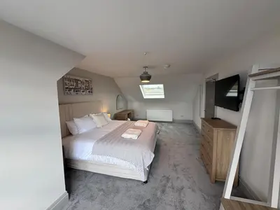 a bedroom with a bed and a flat screen tv at Abhaille Chluaidh - Macaulay Letting in Helensburgh