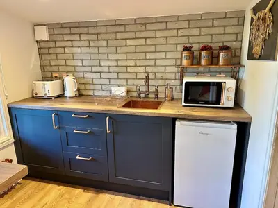 a kitchen with a sink and a microwave at Stylish Cabin with Countryside Views and King Bed in Maybole