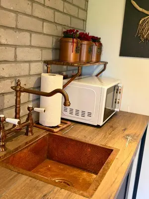 a kitchen counter with a microwave and a sink at Stylish Cabin with Countryside Views and King Bed in Maybole