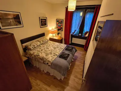 a small bedroom with a bed and a window at A Baronial Hall apartment - great views of Loch Fyne