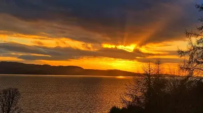 a sunset over a body of water at A Baronial Hall apartment - great views of Loch Fyne