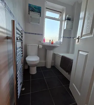 a bathroom with a toilet and a sink and a tub at 3 Bedroom FM Homes & Apartments Wishaw Motherwell in Dalziel