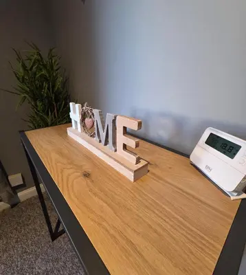 a wooden sign that says me on a table with a clock at 3 Bedroom FM Homes & Apartments Wishaw Motherwell in Dalziel