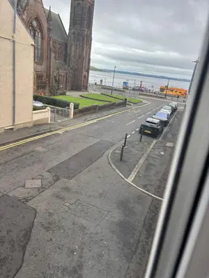 a view of a street with cars parked next to a church at Thistle Tide 13 Nelson Street Largs KA308LN 1st Floor in Largs