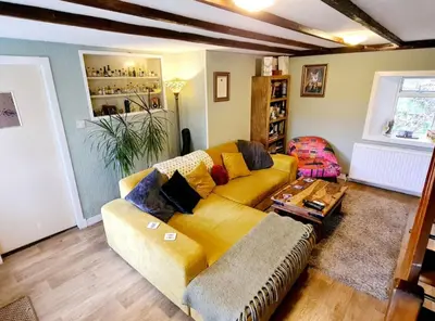 a living room with a yellow couch and a table at Rock Cottage in Isle of Arran