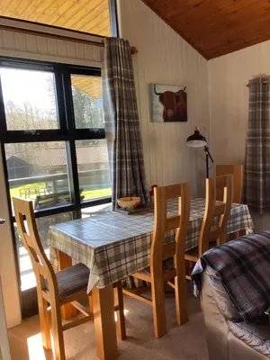 a dining room table and chairs with a table and a couch at Golden Mary in Morenish
