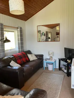 a living room with a leather couch and a mirror at Golden Mary in Morenish