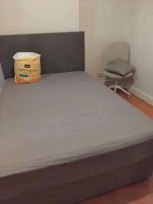 a bed in a room with a chair at 3 Bedroom house Abbey wood London in Moffat