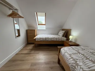 a attic bedroom with two beds and a window at Highland Nook for 4 in Fort William