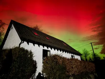 a person standing in front of a white house with the sky at Highland Nook for 4 in Fort William