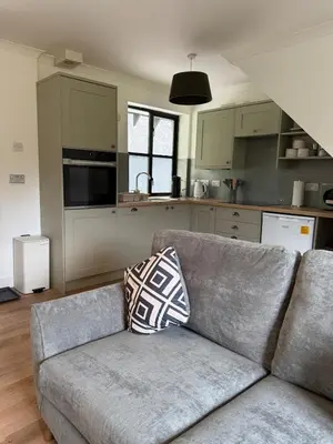 a living room with a couch and a kitchen at Highland Nook for 4 in Fort William