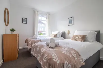 a bedroom with two beds and a window at Ashgrove House - 3 bedroom in Coatbridge