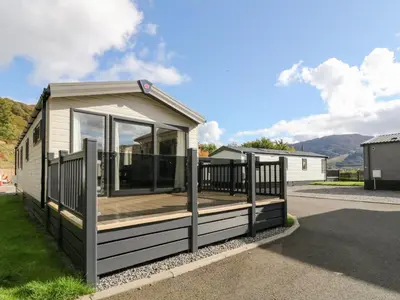 a tiny house with a deck on a street at Altair Lodge in Crieff