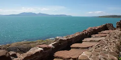 a stone wall next to a large body of water at Seafield Crt, North Shore Beach in Horse Isle
